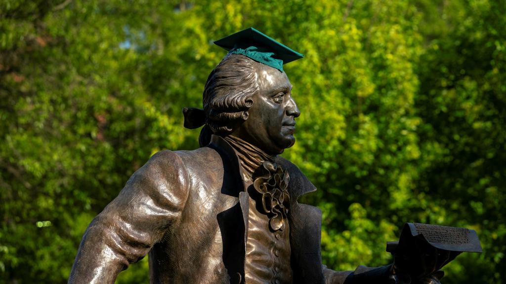 The ż statue wears a green graduation cap.